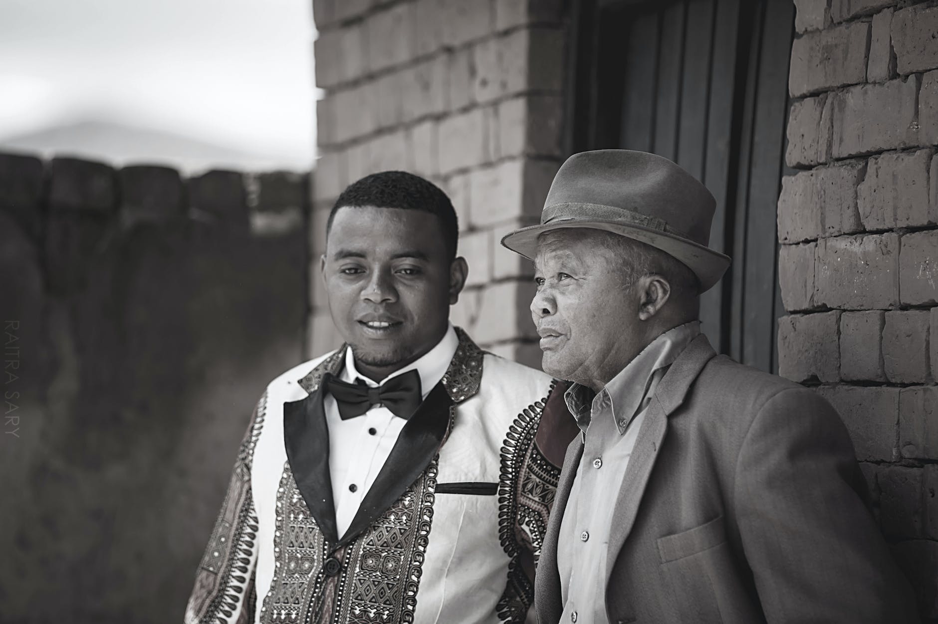 gray scale photo of two men wearing coats