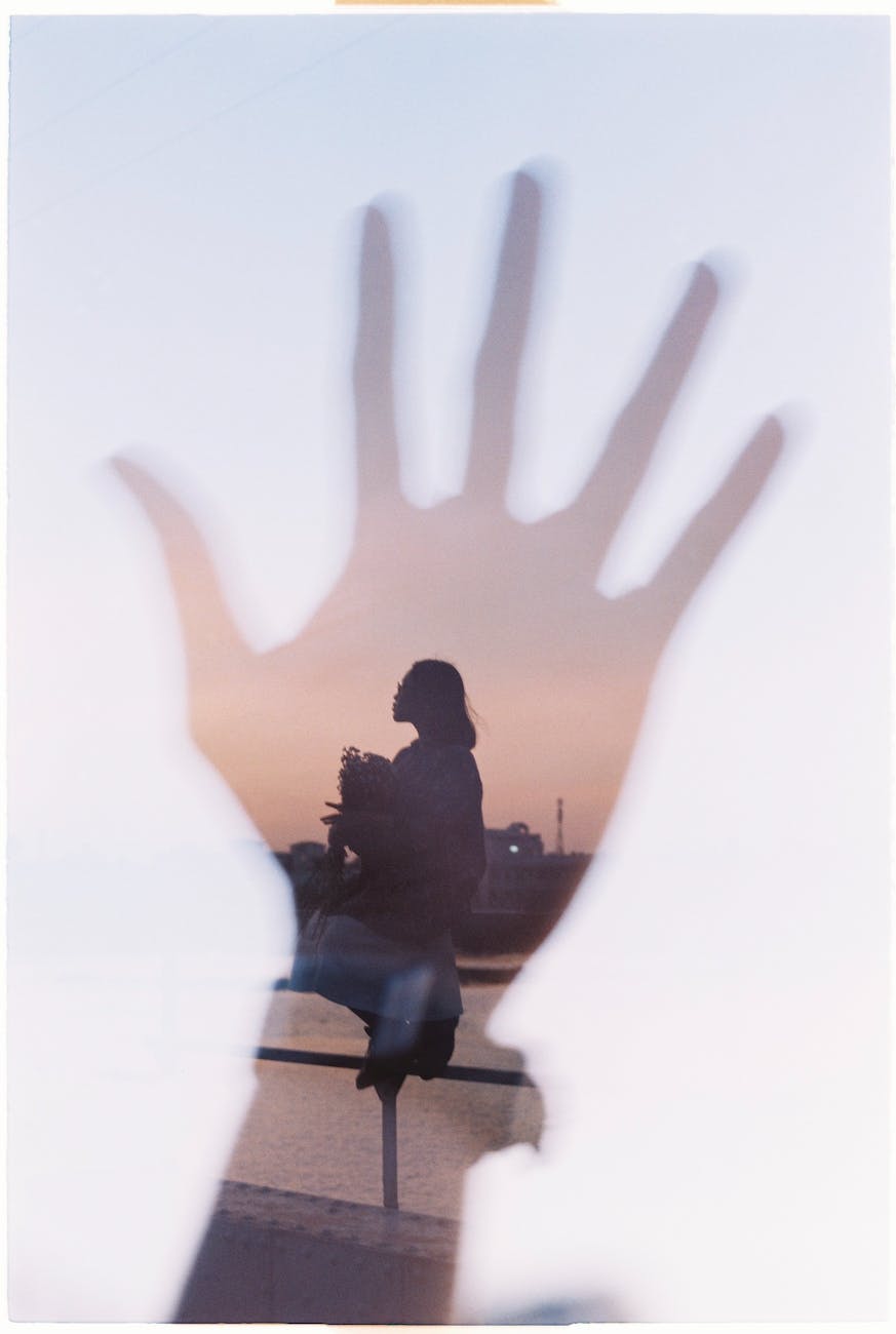 overlapped image of a hand silhouette and woman at riverbank