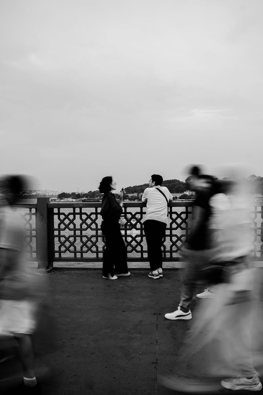 people walking around man and woman on galata bridge