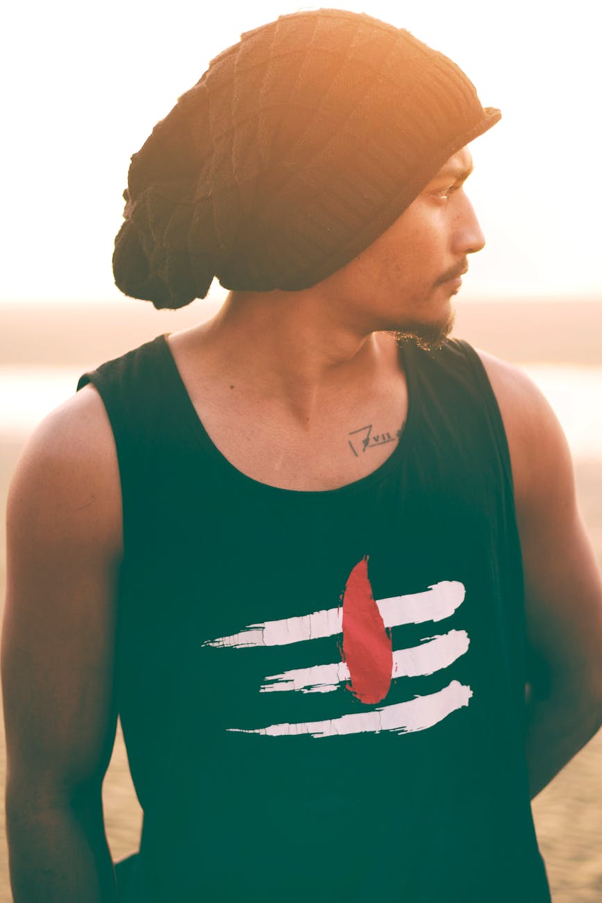 man wears black and white tank top and black knit cap