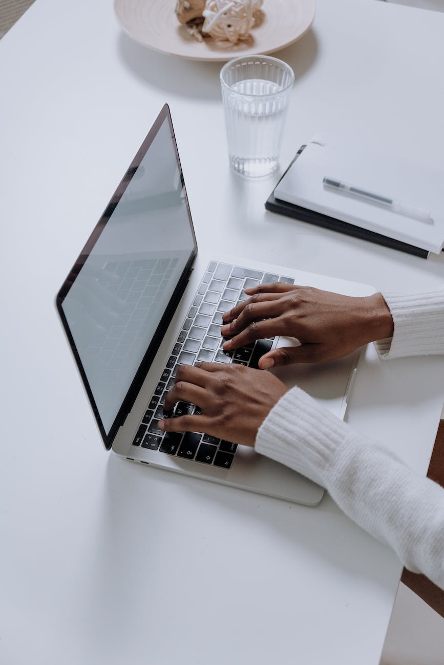 person in white long sleeve shirt using macbook pro