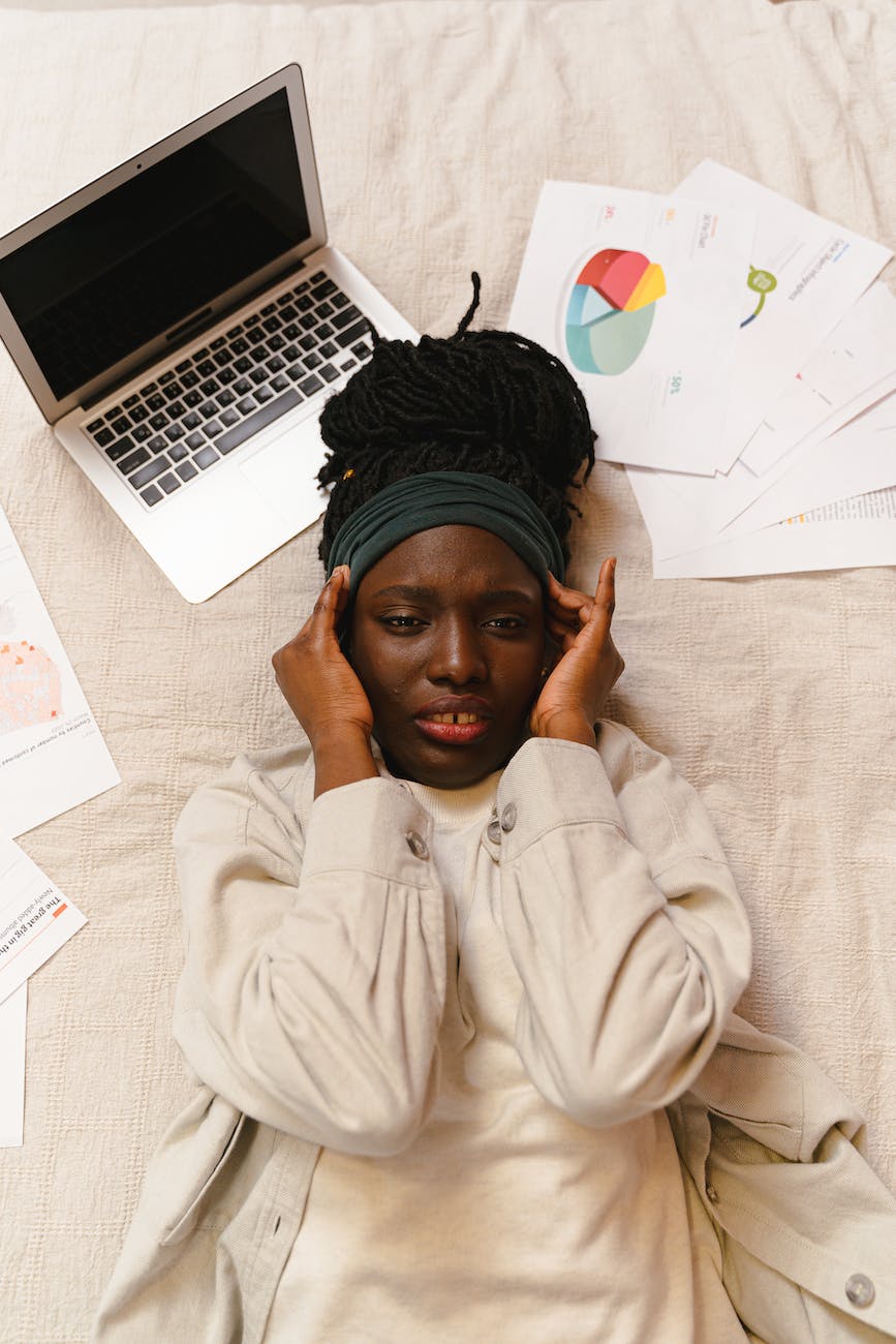 woman in pain lying near a laptop