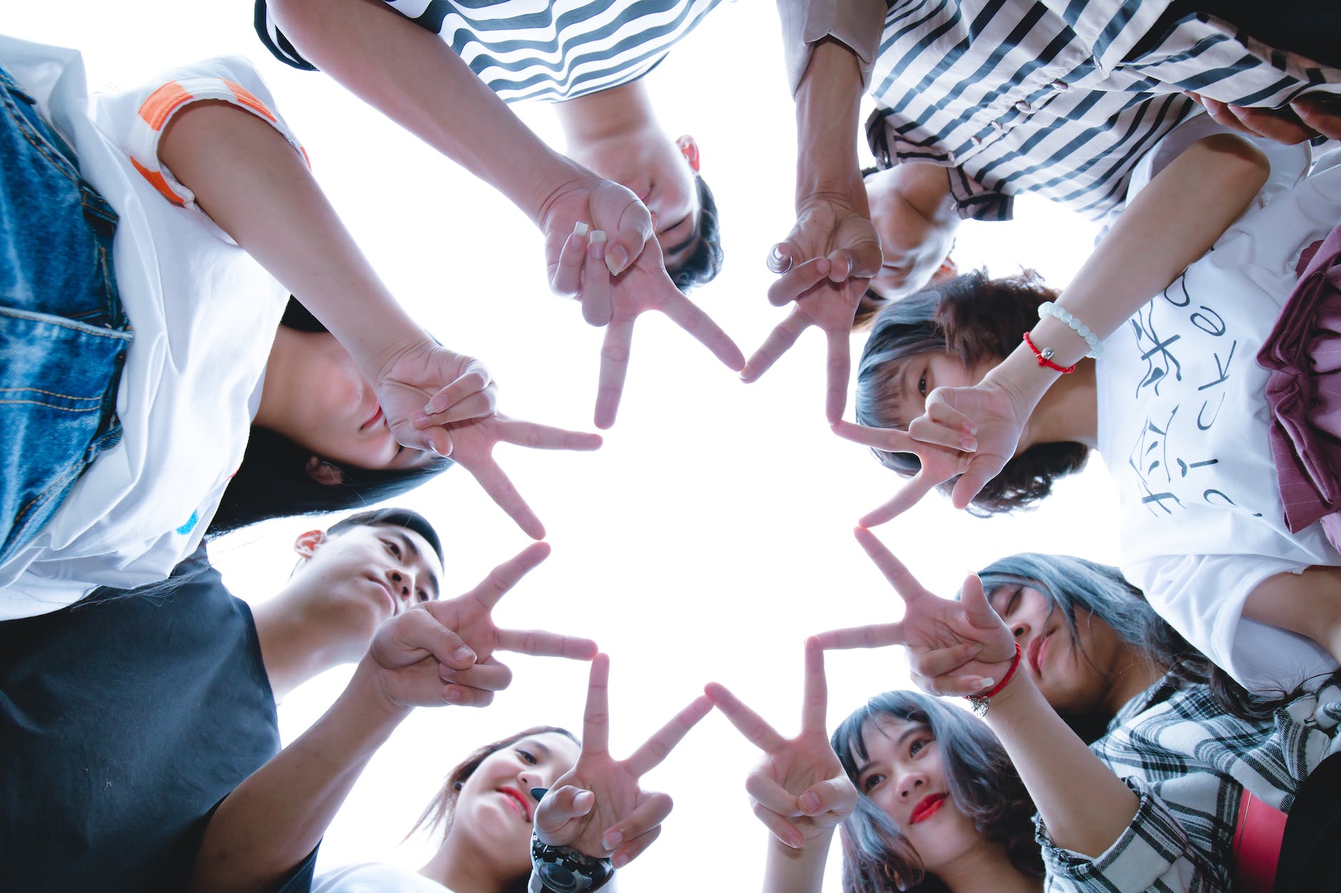 group of people forming star using their hands